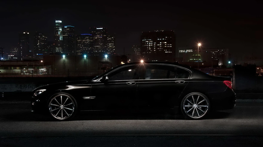 Чёрный BMW 750li на фоне ночного города