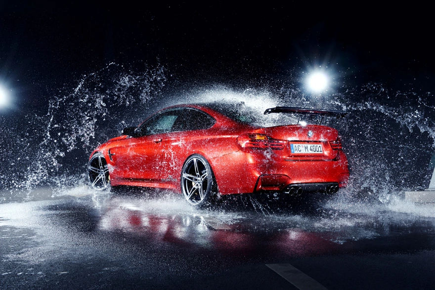 Красный BMW забрызганный водой