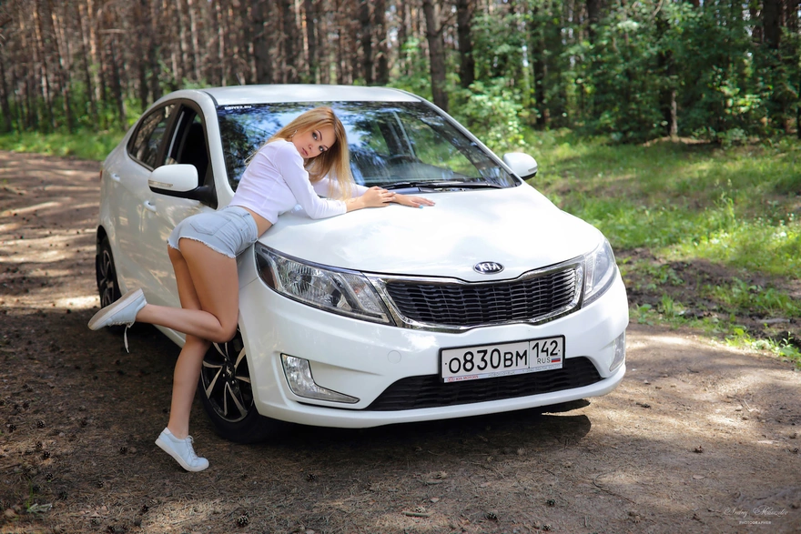 Автомобиль KIA и девушка в лесу
