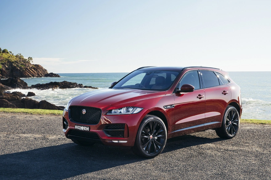 Luxury red Jaguar F-Pace against the sea