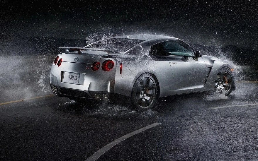 Nissan GTR на скорости поворачивает на мокрой дороге