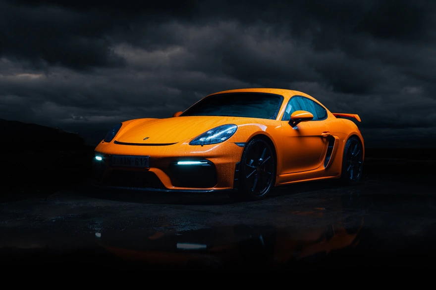 Картинка: Porsche Cayman, gt4, оранжевый, погода, тучи, капли, лужа, отражение