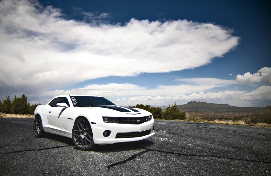 Белый Chevrolet Camaro на дороге с горным пейзажем