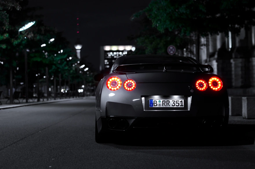 Sports car with glowing taillights at night