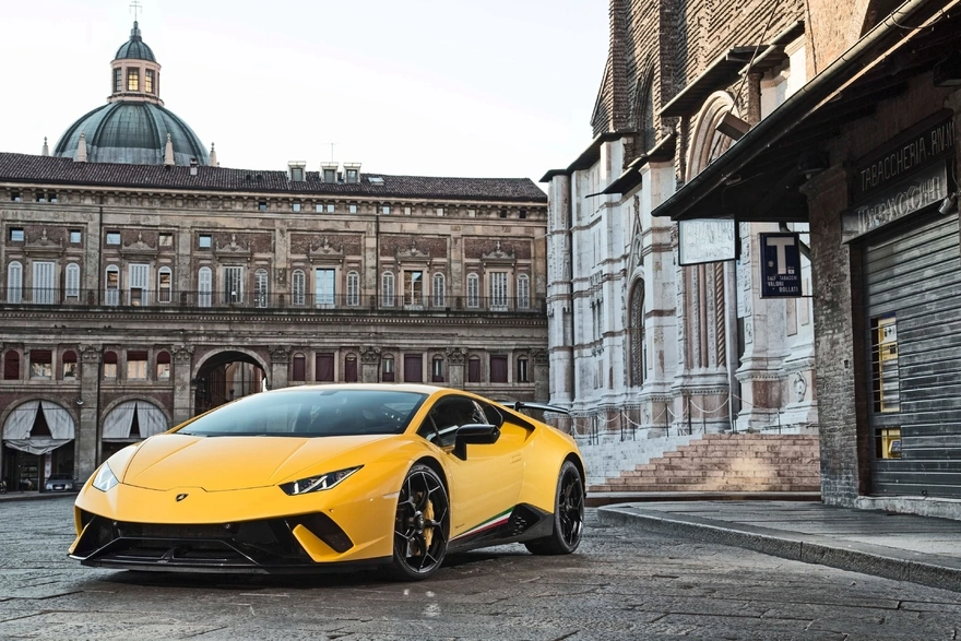 Yellow Lamborghini Huracan Coupe in the background of old buildings