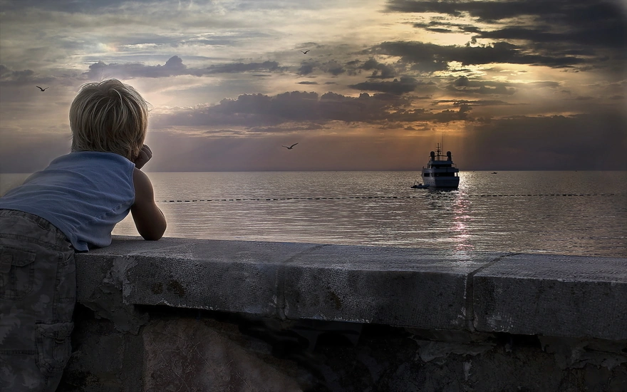 Мальчик наблюдает за плывущим кораблём
