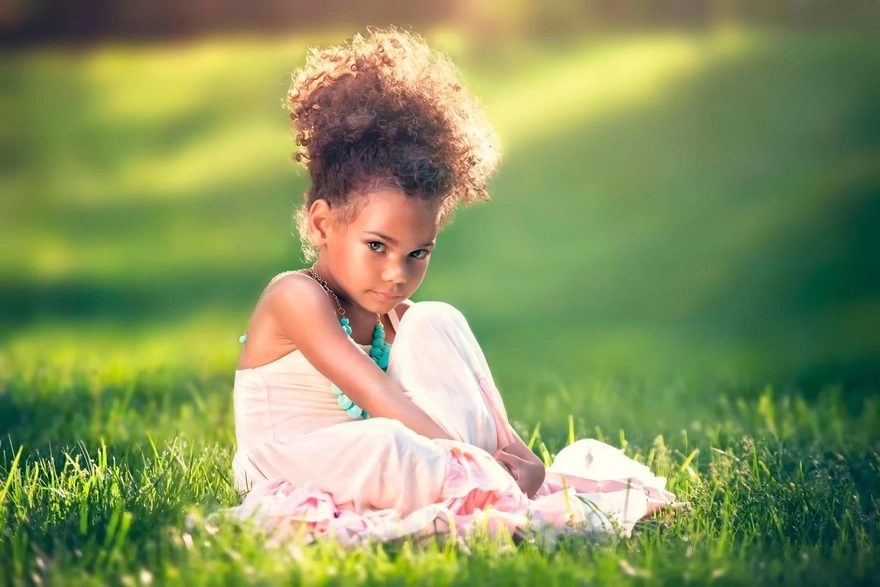 Девочка в платье позирует на траве