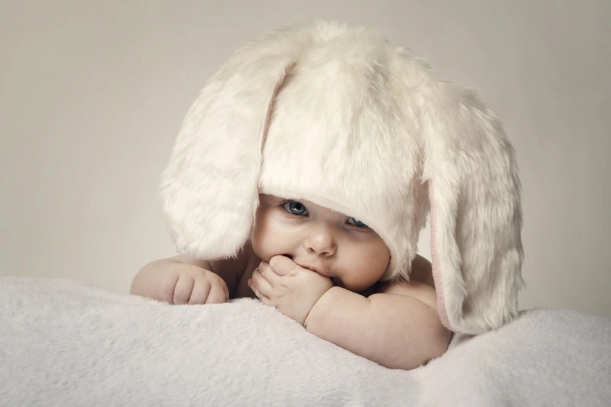Малыш в белой шапочке с ушками зайчика