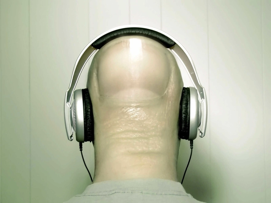 Finger simulating his head listening to music on headphones