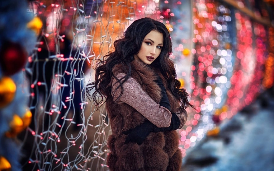 Beautiful brunette in fur jacket posing against the backdrop of luminous garlands