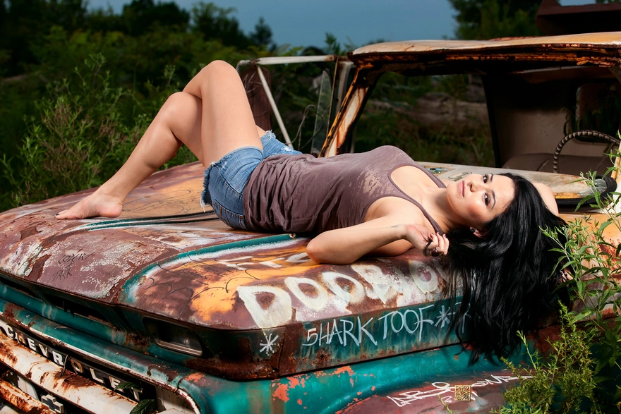 Девушка лежит на капоте старой машины