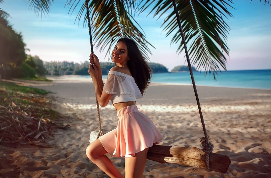 Galina Dubenenko posing on the swing by the sea