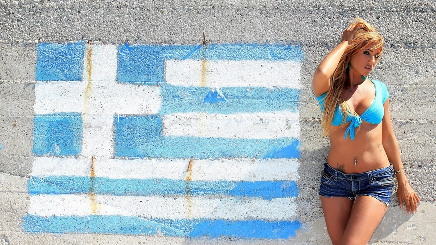 Ashley Bulgari на фоне рисунка флага Греции на стене
