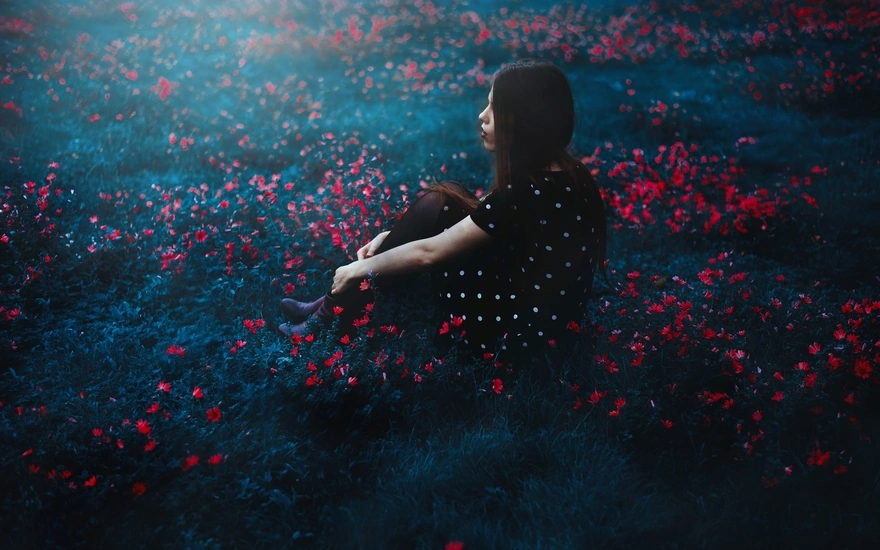 Девушка сидит на цветочной поляне
