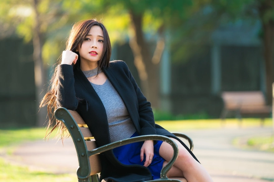Long-haired girl sitting on a park bench