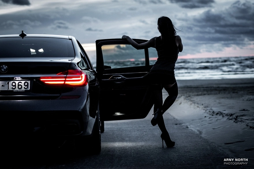 Картинка: Девушка, автомобиль, стоит, дверь, BMW, фара, тучи, пейзаж, дорога, каблуки, Arny North, Photography