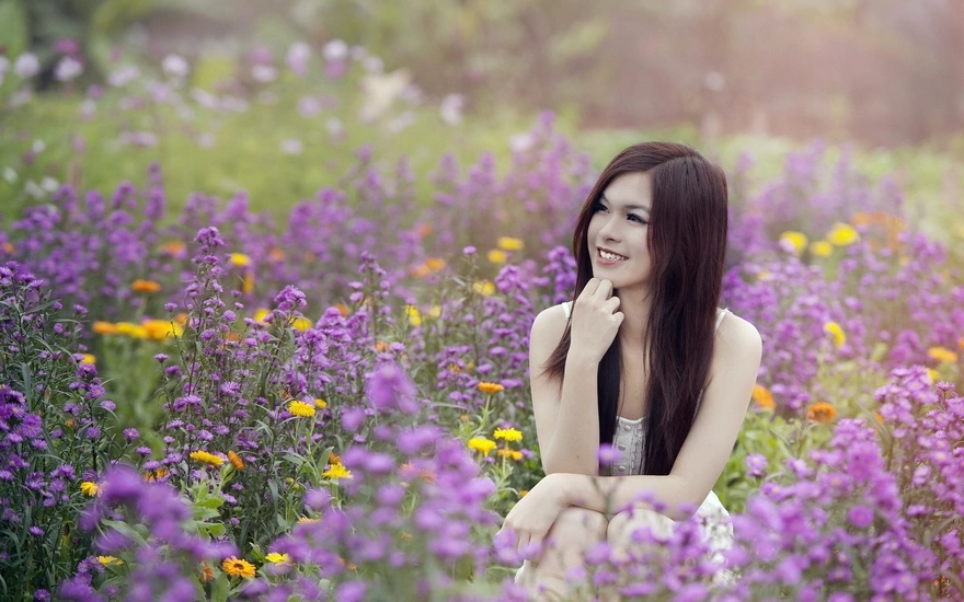 Girl sitting in field of flowers