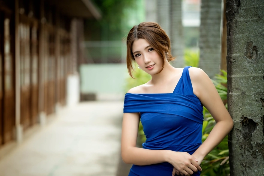 The girl of Asian appearance wearing a blue dress