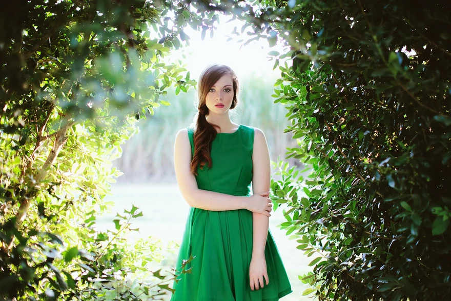 Девушка в зелёном платье среди зелёных веток