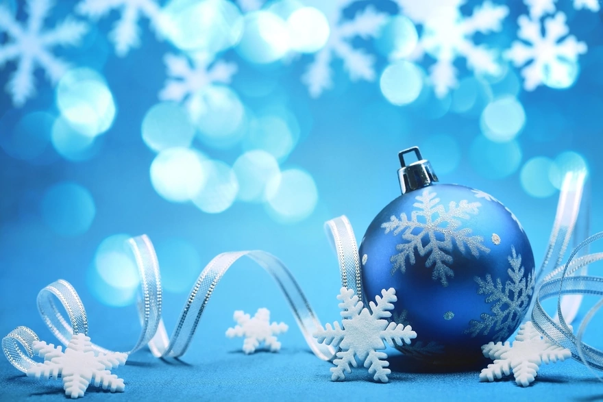 Белая снежинка на синем новогоднем шаре