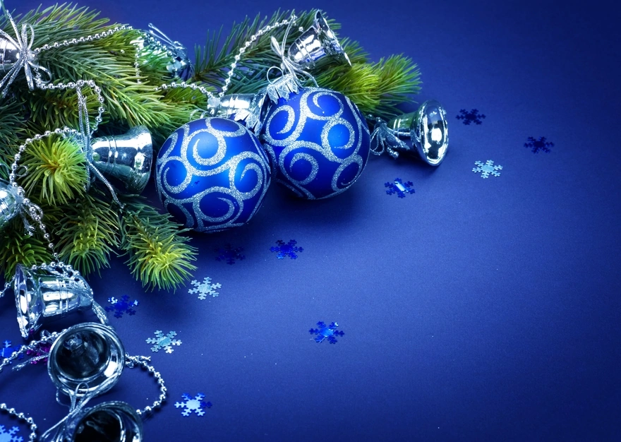 Синие ёлочные шары с серебряными колокольчиками лежат в ветках ели