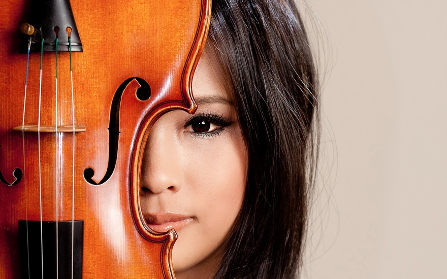 Девушка выглядывает из-за скрипки