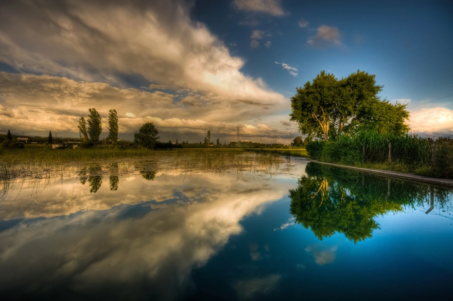 Отражение в воде деревьев и облаков