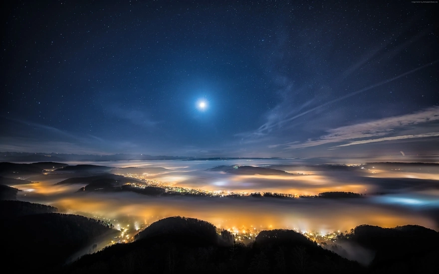The night sky above the town covered with fog