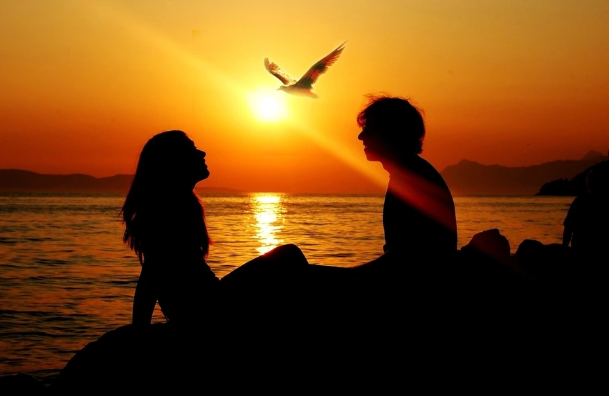 Романтическое свидание пары на берегу моря при закате солнца