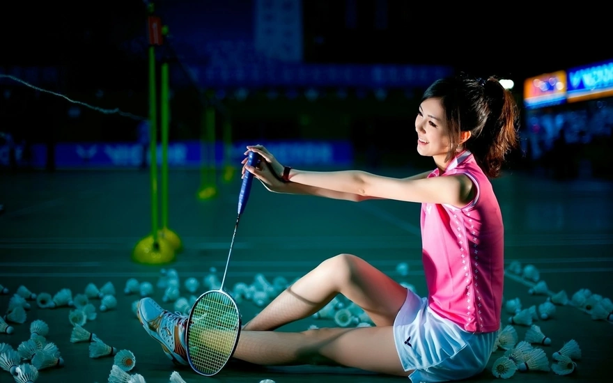 Girl posing with racket and shuttlecocks