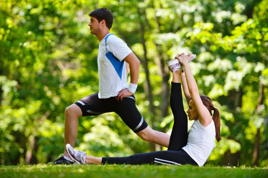 Мужчина и девушка занимаются спортом на свежем воздухе