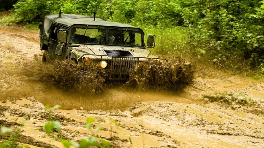 Hummer rides through a mud puddle