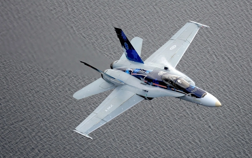 Истребитель CF-18 Hornet летит над поверхностью воды