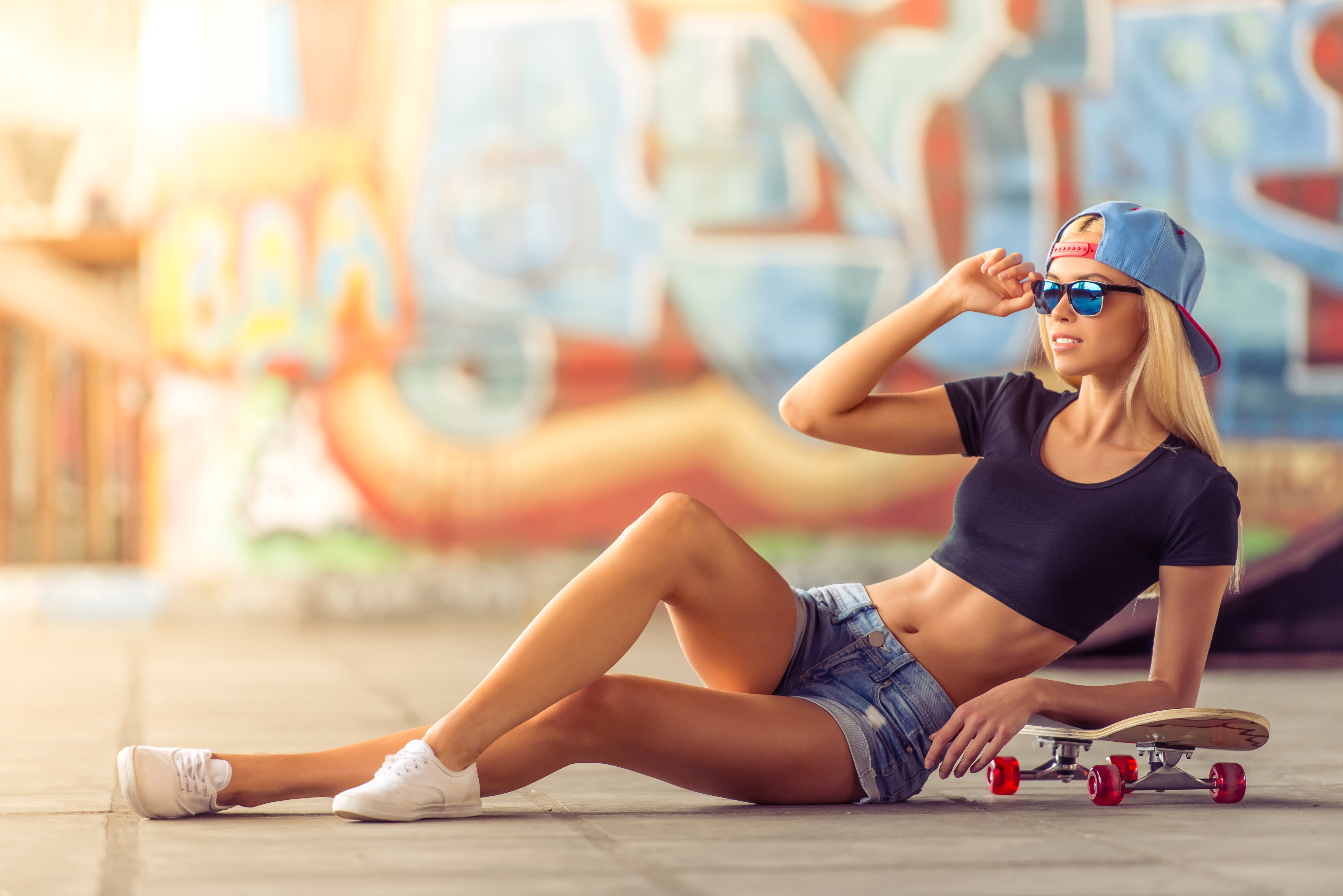 Картинка: Девушка, блондинка, кепка, очки, лежит, скейтборд, граффити