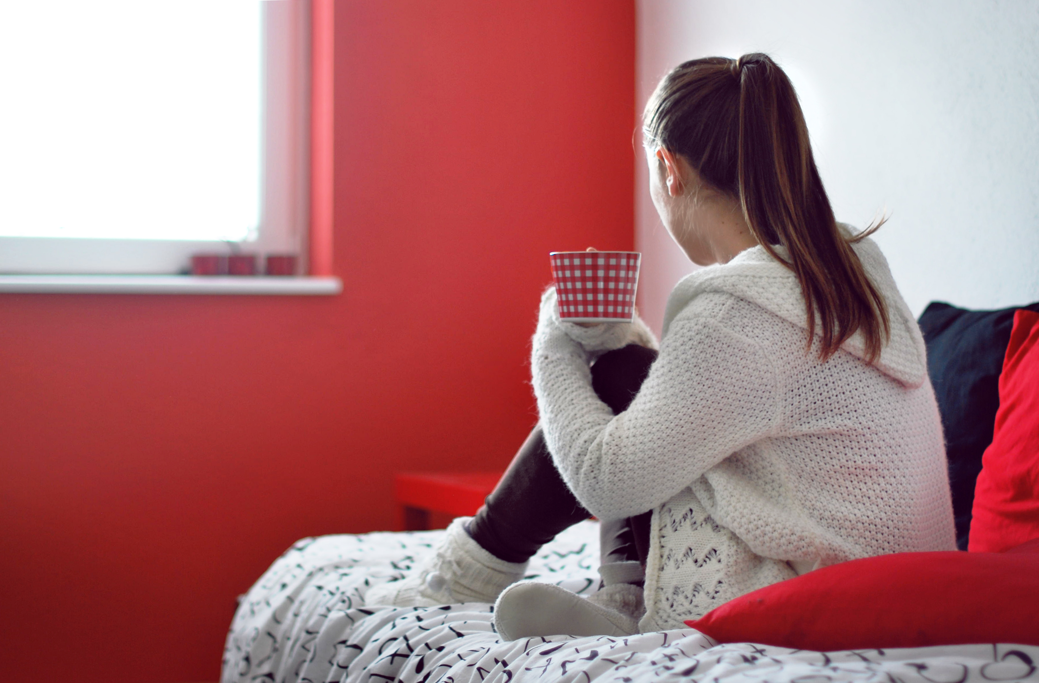 Image: Girl, shirt, sitting, mug, back, sofa, pillows, red