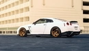 Картинка: Белый Nissan GT-R на фоне белого здания.