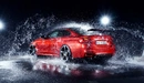 Image: Red BMW spattered with water.