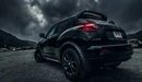 Картинка: Чёрный Nissan Juke на фоне серых туч.