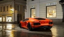 Картинка: Оранжевый суперкар на мокрой дороге.