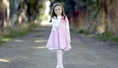 Картинка: Девочка в розовом платье гуляет по парку