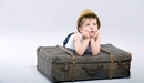 Картинка: Мальчик упёрся локтями в чемодан и смотрит на верх