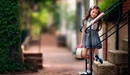 Картинка: Девочка стоит на ступеньках лестницы держась за перила.