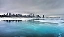 Картинка: Ледяная река на фоне города и серых туч