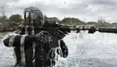 Картинка: Киборг с оружием прицеливается стоя в воде