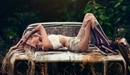 Картинка: Девушка позирует лёжа на ржавом старом авто