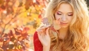 Картинка: Девушка держит в руке осеннюю листву.