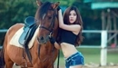 Картинка: Азиатка позирует рядом с лошадью.