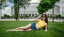 Картинка: Lioka Grechanova позирует в очках лёжа на зелёной лужайке.
