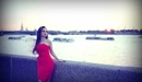 Картинка: Девушка в красном платье позирует на набережной.