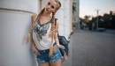 Картинка: Блондинка с длинными косичками в джинсовых шортах.